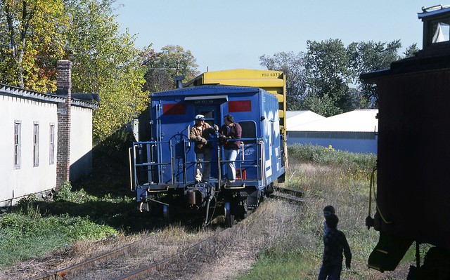 Some young railfans watch as a Conrail crew rides away on a transfer caboose